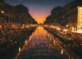 reflective photography of string lights above river