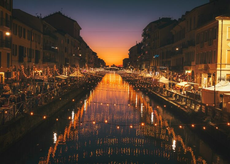 reflective photography of string lights above river
