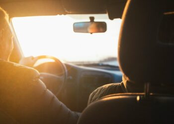 man driving car during golden hour