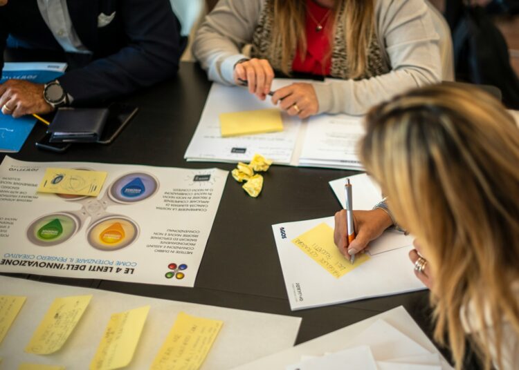 a group of people sitting around a table with papers