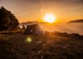 dome tent on mountain top with sun as background photo