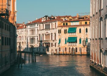 brown and white concrete building beside body of water during daytime