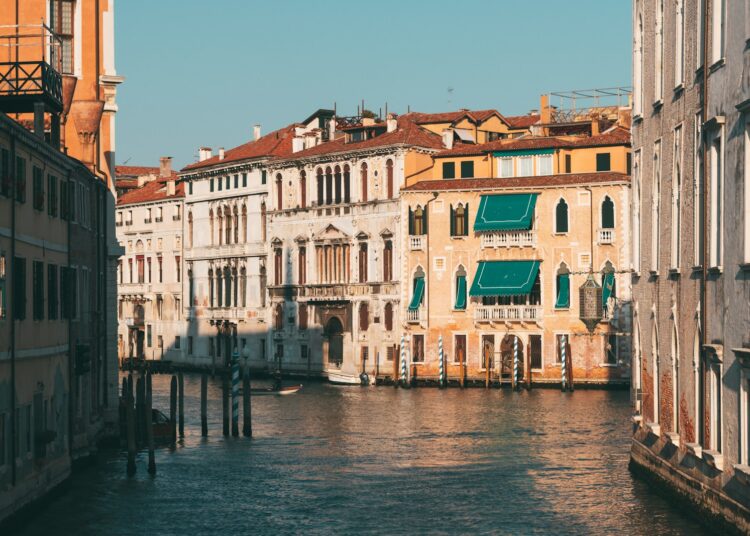 brown and white concrete building beside body of water during daytime