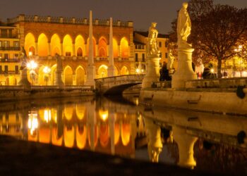 white concrete building near body of water during night time