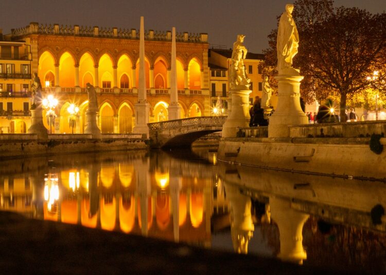 white concrete building near body of water during night time