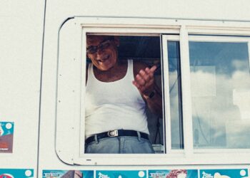 man wearing white tank top near window