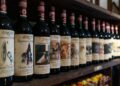 a row of bottles of wine on a wooden shelf