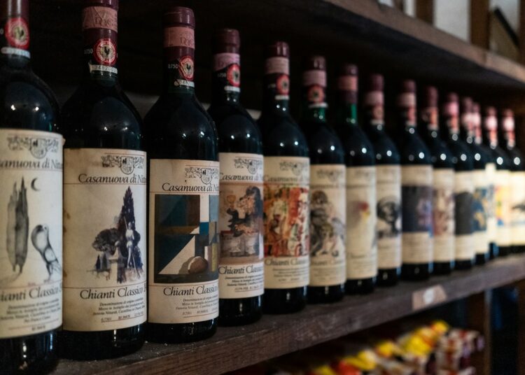 a row of bottles of wine on a wooden shelf