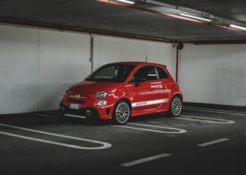 red 5 door hatchback parked on garage