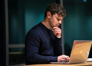man in black long sleeve shirt sitting in front of macbook