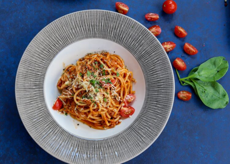 pasta with red sauce on white ceramic round plate