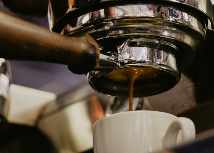 white ceramic mug under espresso maker