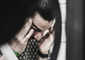 man holding his temples and looking down
