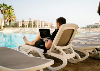 man on sun lounger using laptop