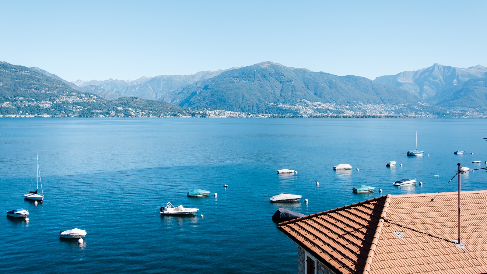 assorted-color speed boats near mountains