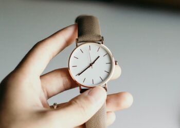 person holding analog watch