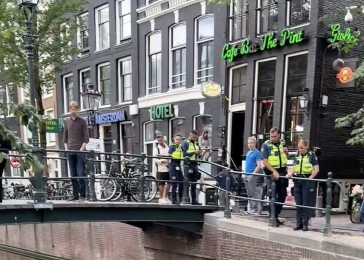 Dwarsligger blokkeert grachtverkeer en ligt erbij alsof hij Ibiza heeft geboekt