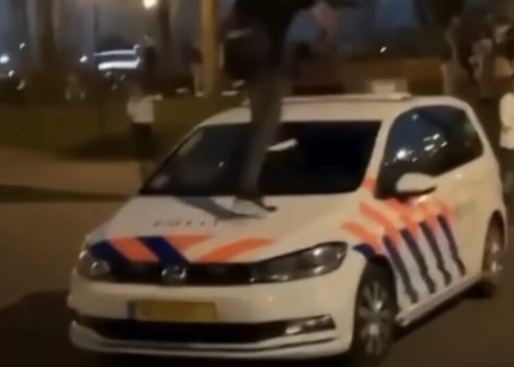 Man springt op politieauto alsof het een trampoline: omstanders filmen alles