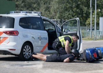Nederlandse politie trapt jongetje van zijn Vespa af en begint knietjes uit te delen.