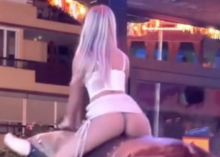 Dame in een te kort rokje neemt plaats op een mechanische stier en dat is niet zo slim